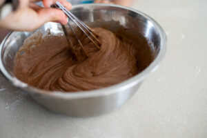 Brownie batter in a mixing bowl with a spatula