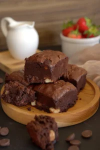 A batch of fudgy brownies on a wooden cutting board.