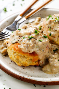 A plate of homemade biscuits smothered in creamy sausage gravy, ready to be served.