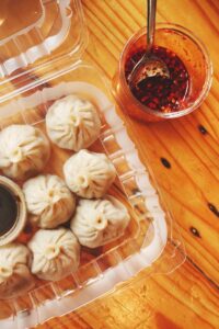 Boiled dumplings served with soy sauce and chili oil.