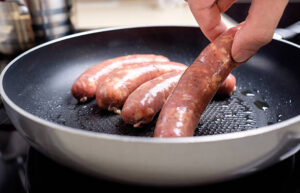 Ground pork sausage sizzling in a skillet, perfectly browned for homemade gravy.