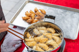 Dumplings frying in a pan with golden-brown crusts