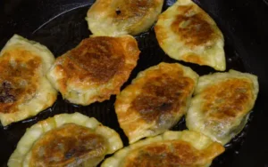 Golden pan-fried dumplings on a skillet for a crispy texture.