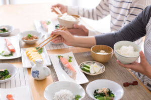 A Japanese meal with chopsticks and a bowl of rice on a traditional wooden table.