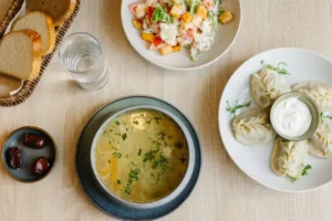 A light dinner plate with a bowl of soup, salad, and a glass of water.