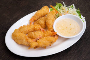 Crispy Bang Bang Shrimp served with creamy dipping sauce and a side salad.