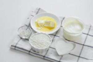 Basic ingredients for making biscuits, including flour, butter, milk, and baking powder.