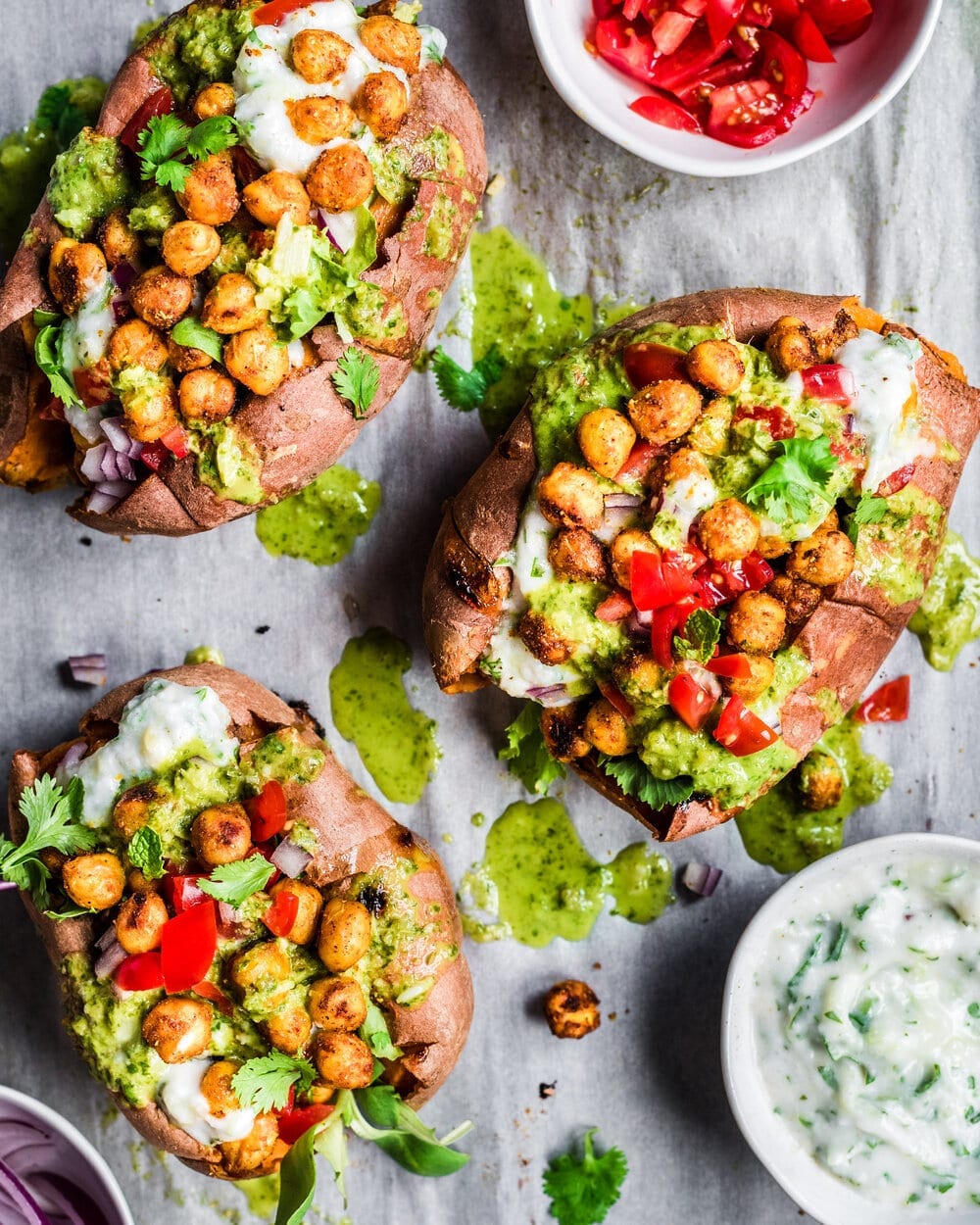 Roasted sweet potatoes stuffed with spiced chickpeas, avocado sauce, and fresh herbs, showcasing how to make beans taste good.