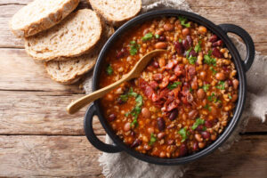 Ingredients for making beans taste good, including onions, garlic, spices, and fresh herbs.