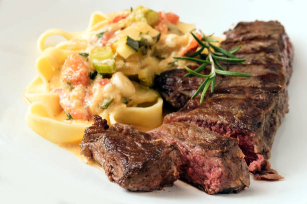 A plate of garlic butter steak pasta with fresh parsley garnish