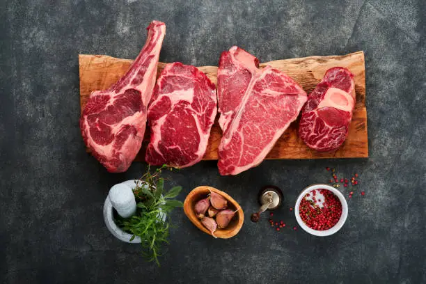 Different steak cuts displayed on a butcher’s board with labels