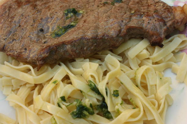 Delicious steak pasta served on a rustic plate with fresh herbs and Parmesan cheese